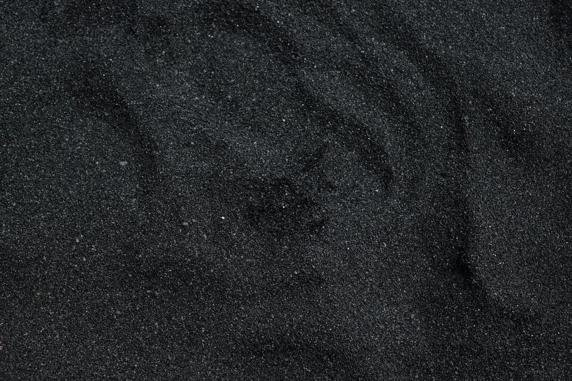 A close up of a pile of black sand.