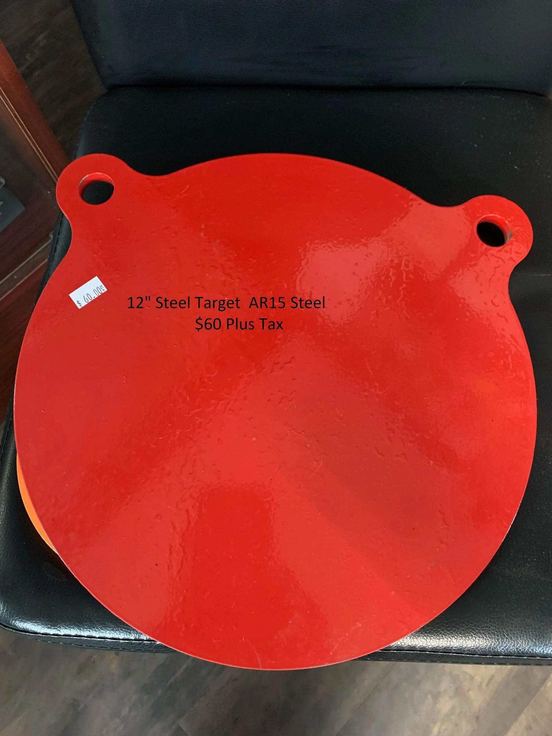 A red circle with holes in it is sitting on a black chair.