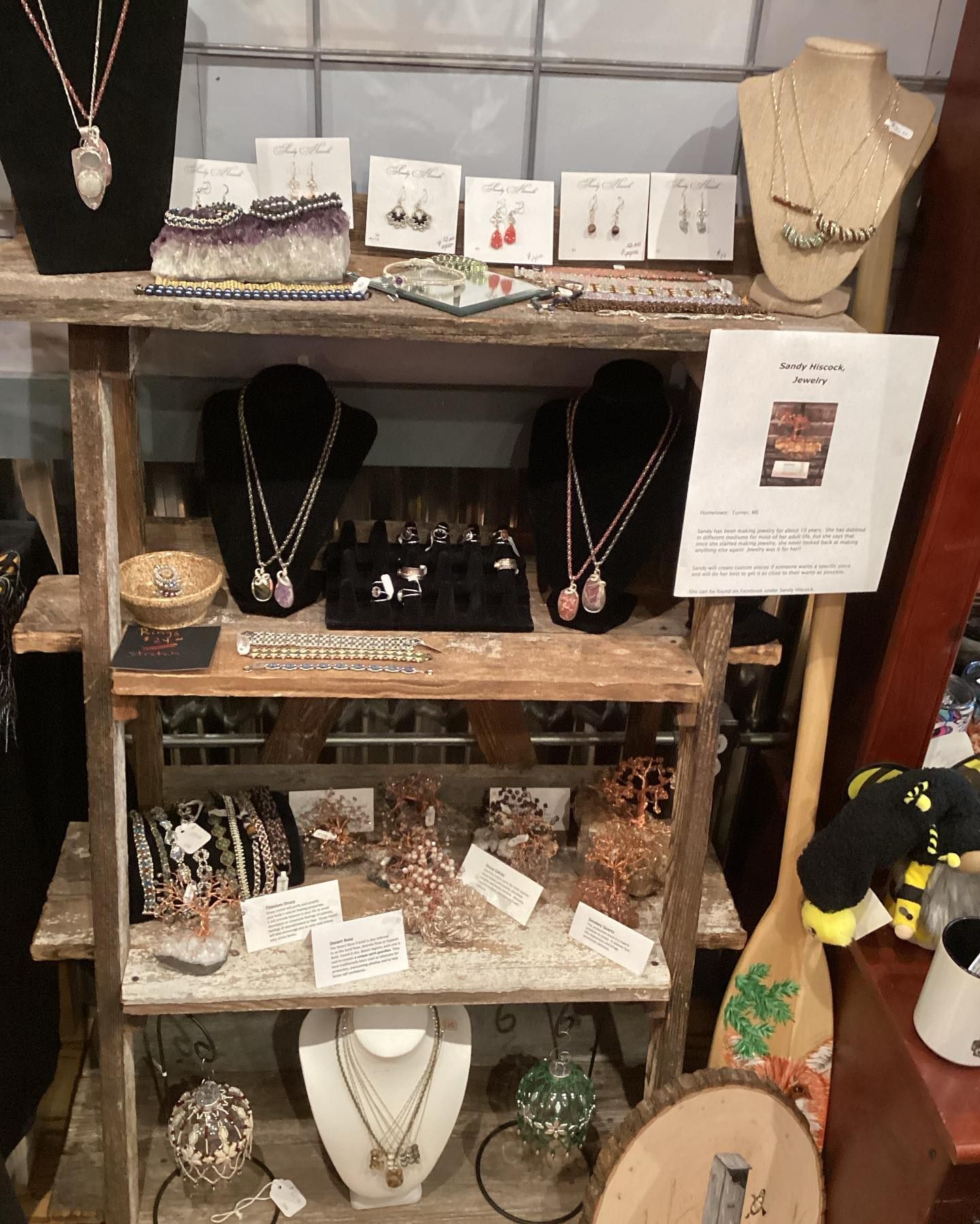 A display of necklaces and earrings on a wooden shelf