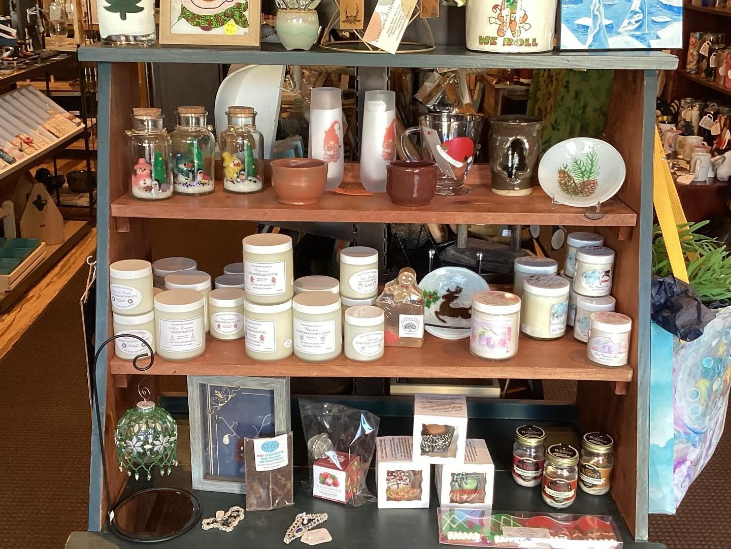 A shelf filled with candles and other items in a store.