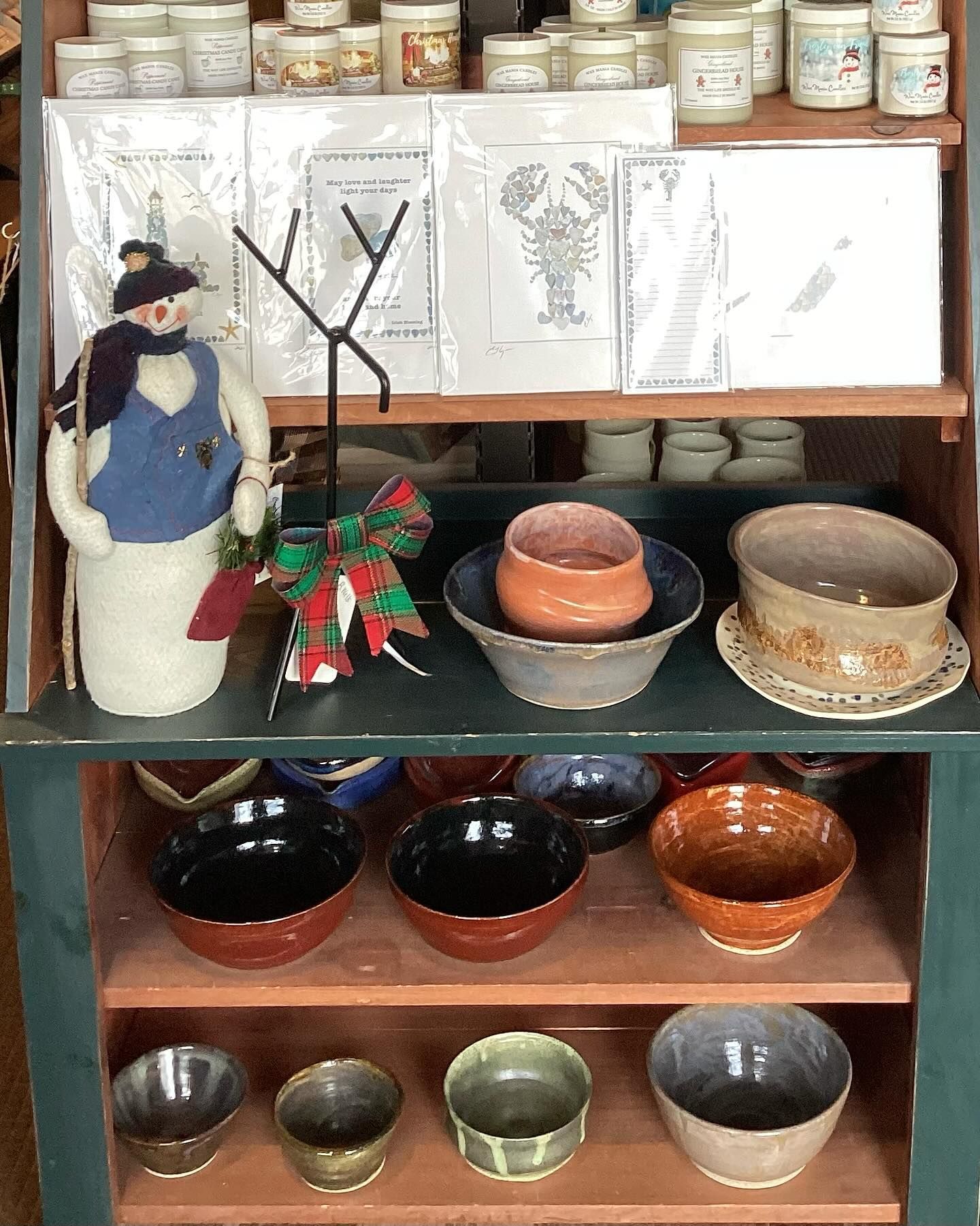 A shelf with bowls and a snowman on it