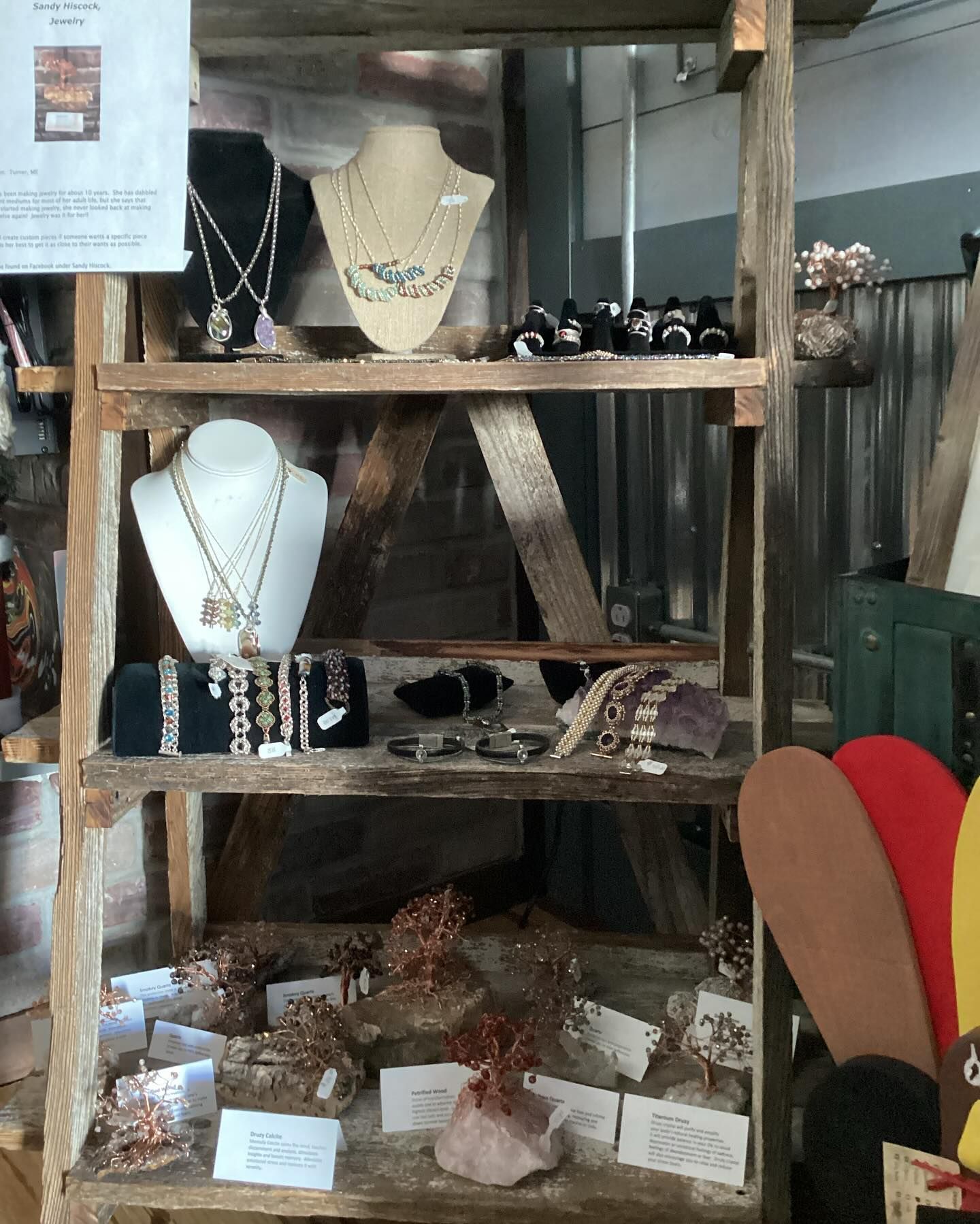 A display of necklaces and bracelets on a wooden shelf