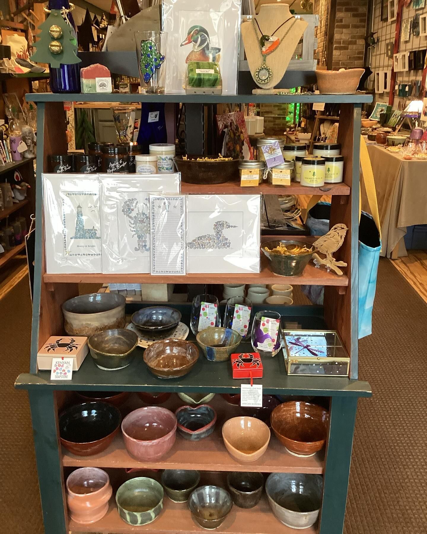 A shelf filled with bowls and cards in a store.
