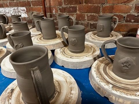 A bunch of mugs are sitting on top of a table.