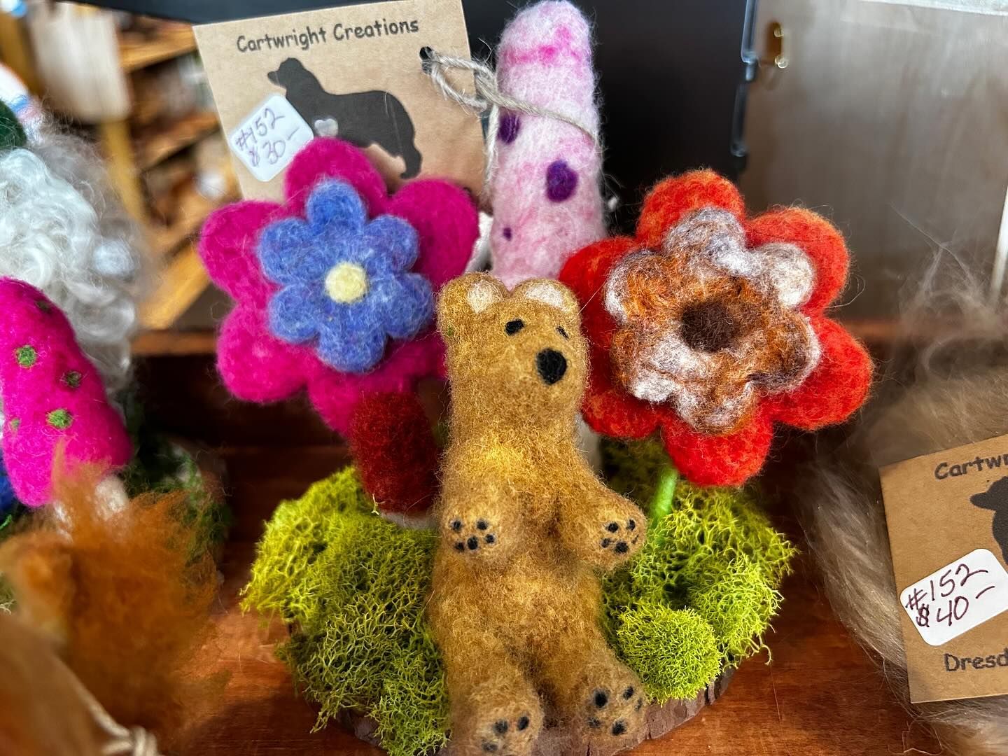 A brown teddy bear sitting on top of a pile of flowers.