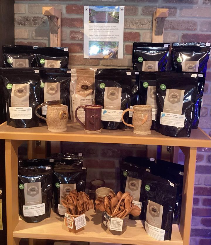A shelf filled with bags of coffee and mugs