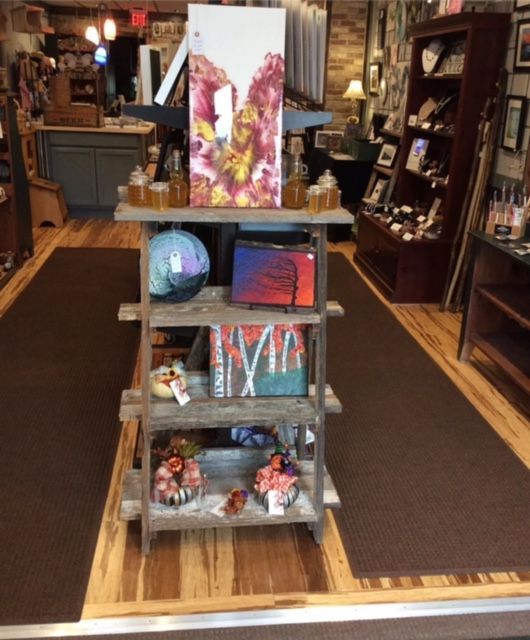 A wooden shelf with a painting on top of it