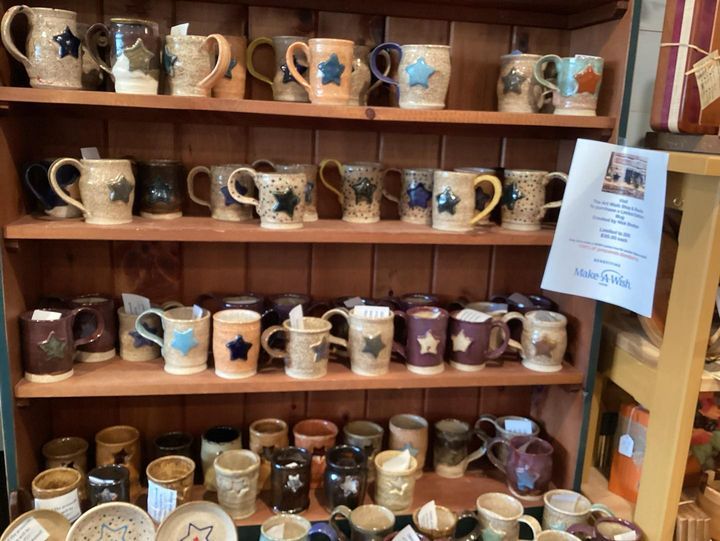 A shelf filled with lots of mugs and plates