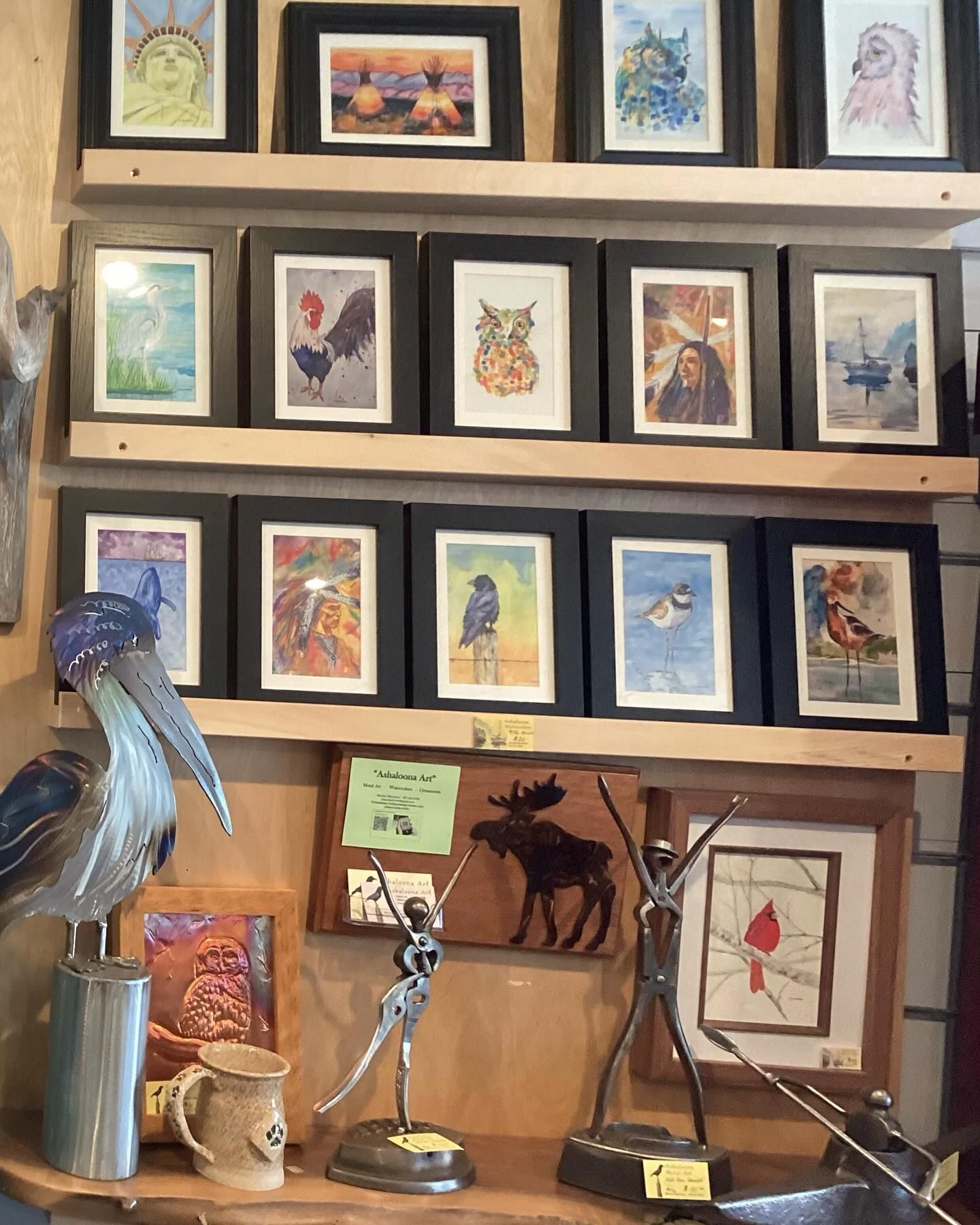 A shelf full of pictures and a statue of a moose