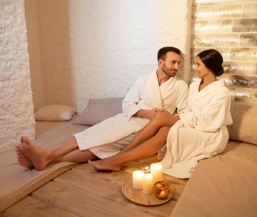 A man and a woman are sitting on a couch with candles