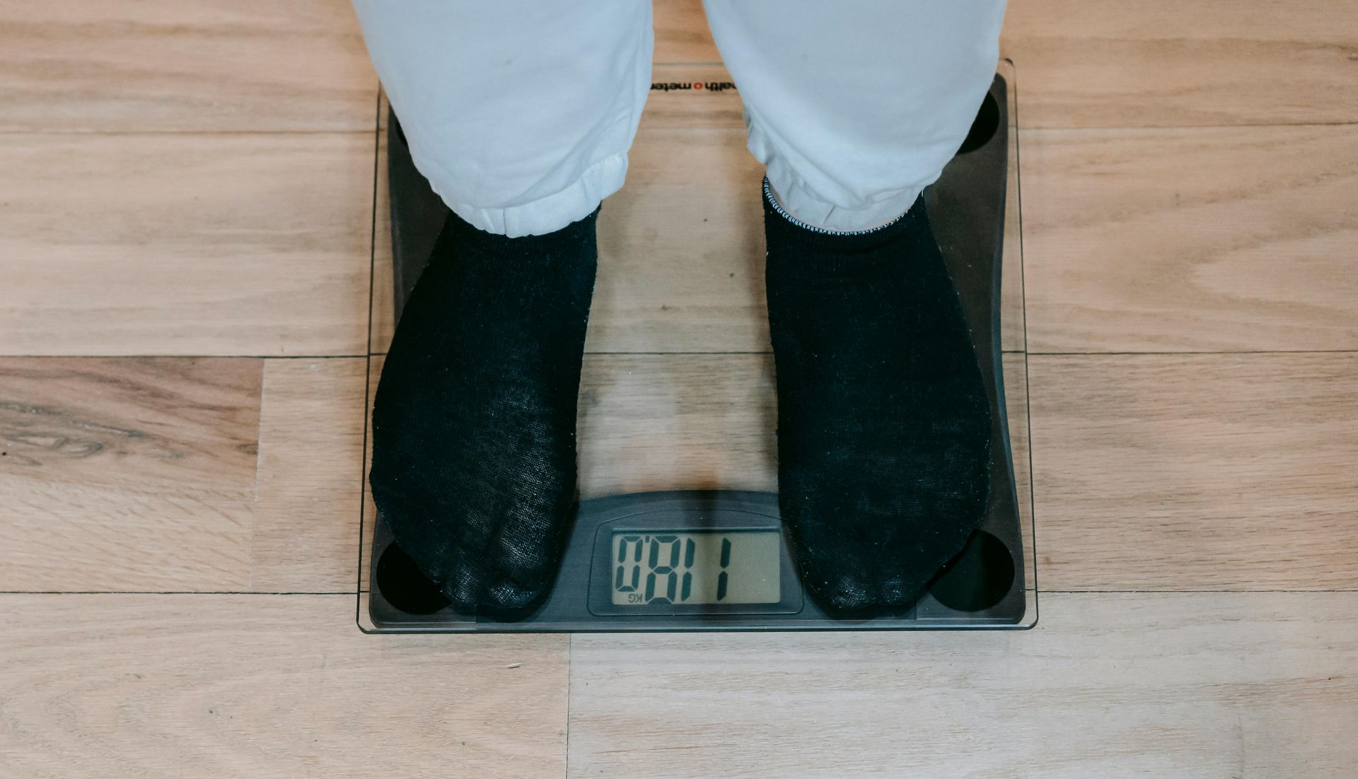 A person is standing on a scale with their feet on it.