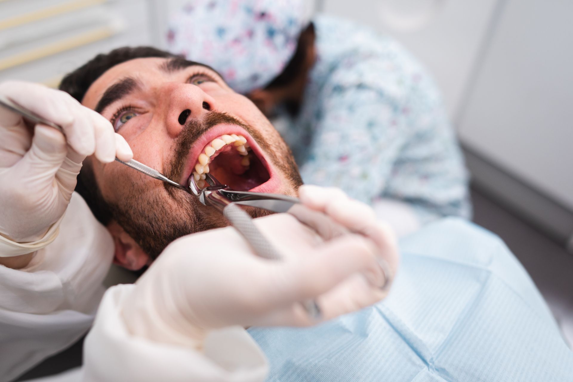 Man in dental chair with mouth open, dentist using tools. Man in dental chair with mouth open, dentist using tools.