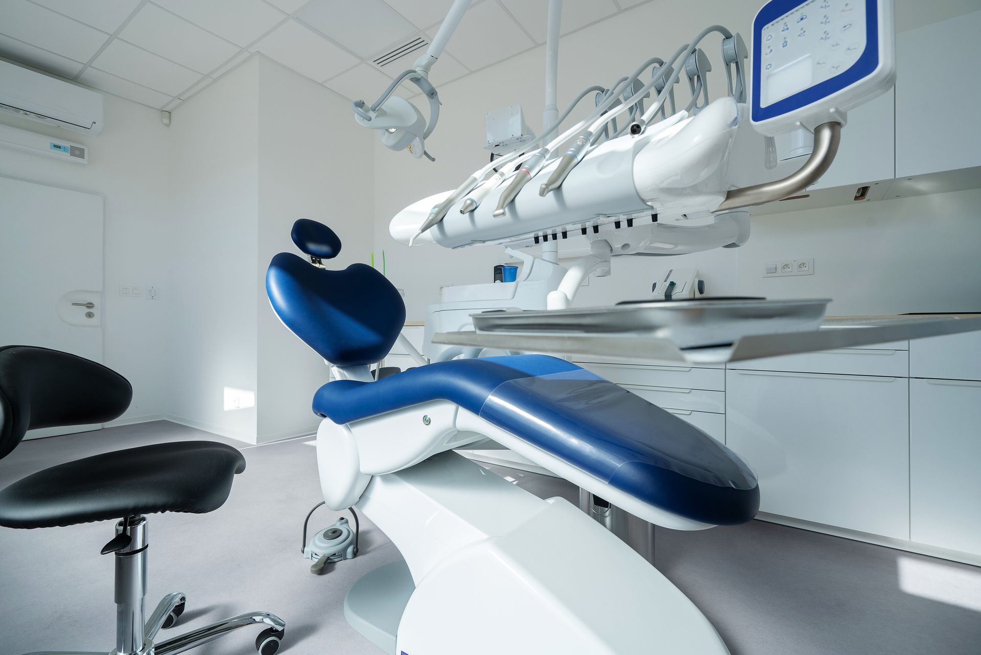 Dentist examining a patient's teeth in a bright dental office. Close-up on instruments and an X-ray screen. Dentist examining a patient's teeth in a bright dental office. Close-up on instruments and an X-ray screen.