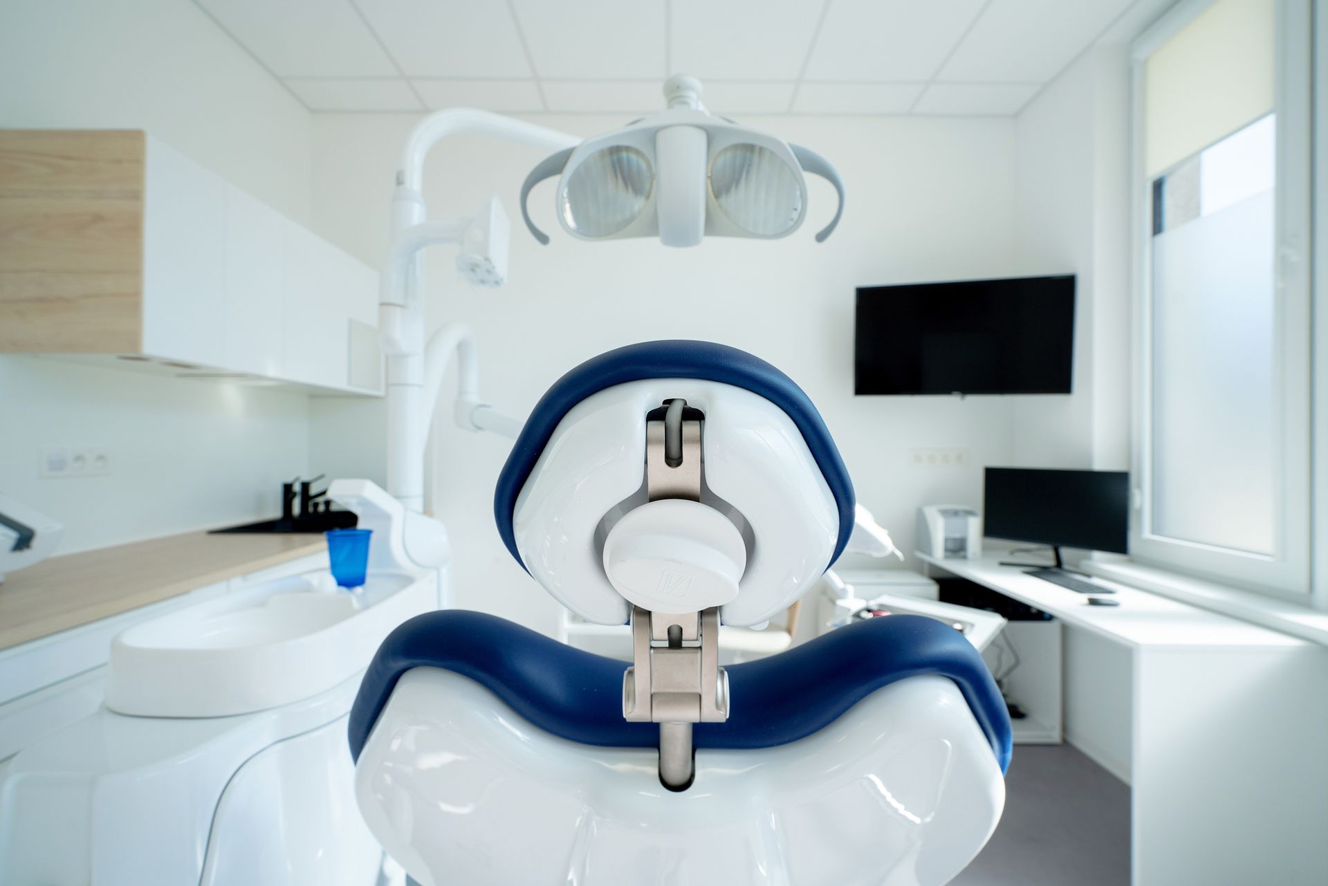 Dentist examining a patient's teeth in a dental office. White coat, dental chair, tools visible. Dentist examining a patient's teeth in a dental office. White coat, dental chair, tools visible.