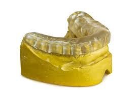 Clear mouth guard on a yellow dental cast used for making dental appliances. Clear mouth guard on a yellow dental cast used for making dental appliances.