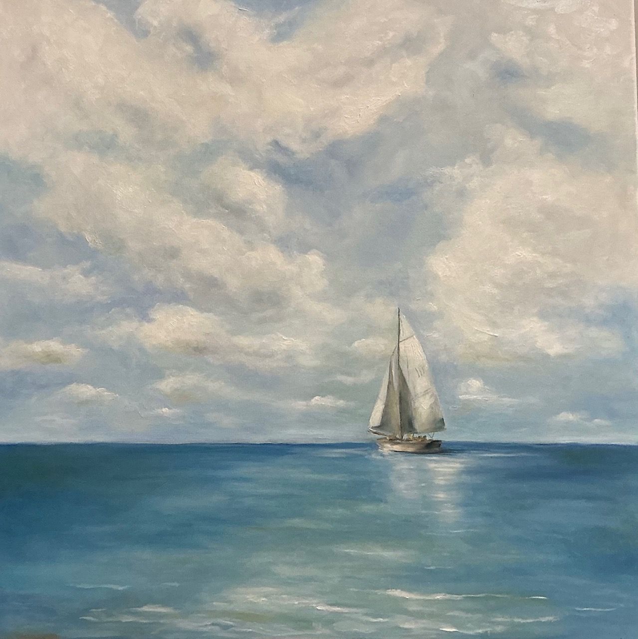 Sailboat on a calm blue sea under a cloudy sky