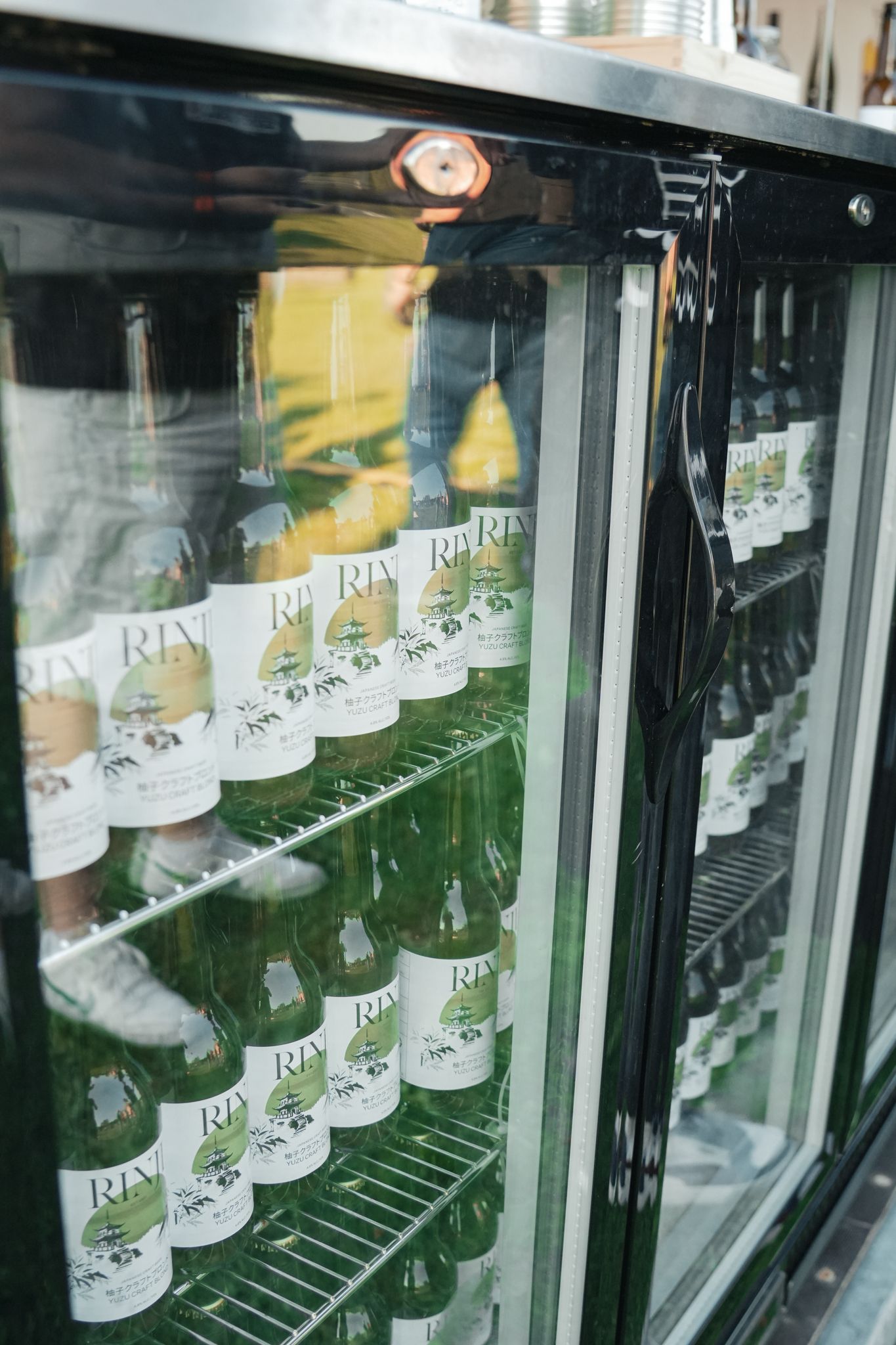 Een koelkast gevuld met heel veel flessen bier.