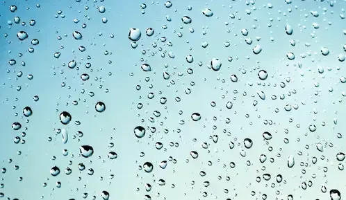 Water droplets on glass surface representing moisture exposure
