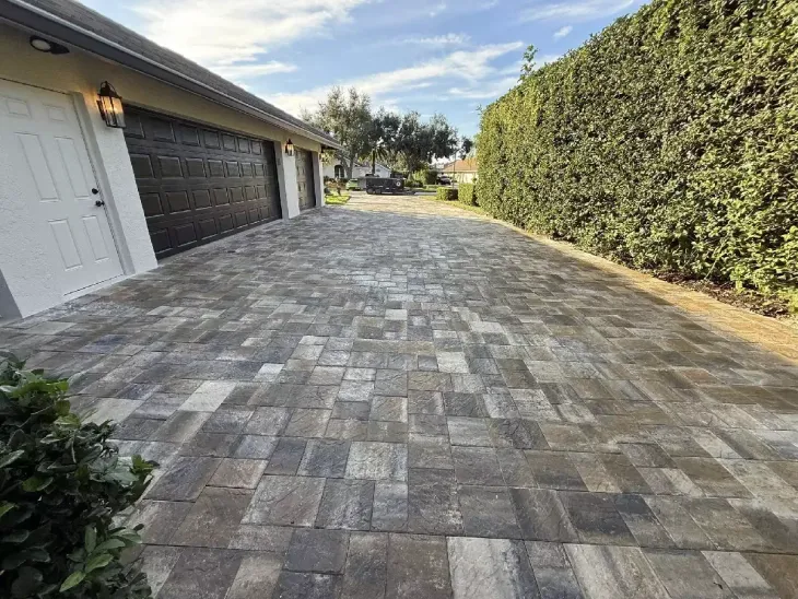 Gray multi-size concrete paver driveway beside residential garage in Sarasota, Florida