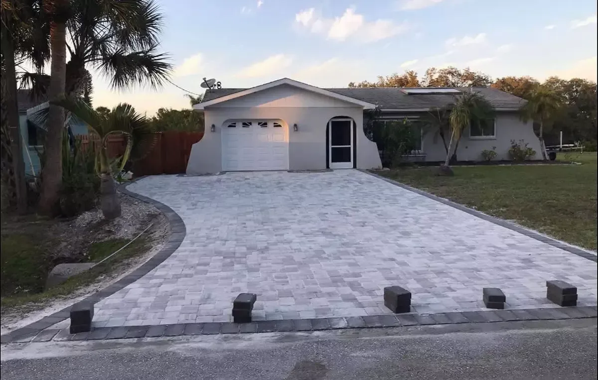 Light gray concrete paver driveway in front of single-story home