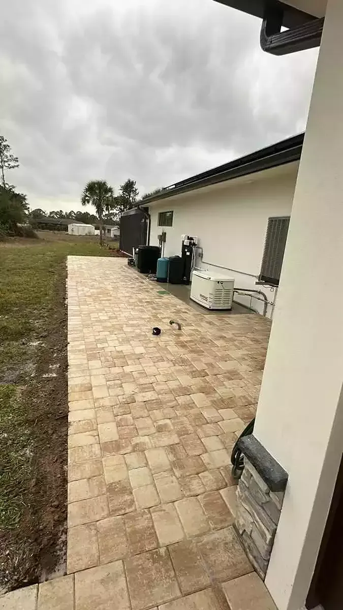 Beige concrete paver patio along side of residential home