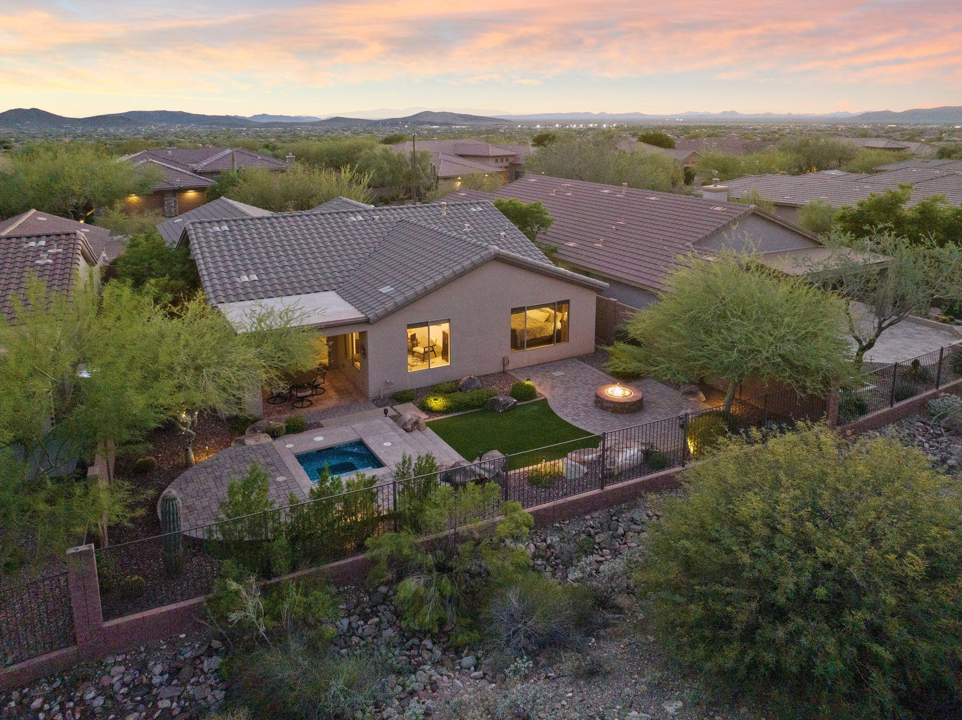 Photo by Phoenix Drone Pros, Robert Biggs, An aerial view of a house with a pool in the backyard surrounded by trees.