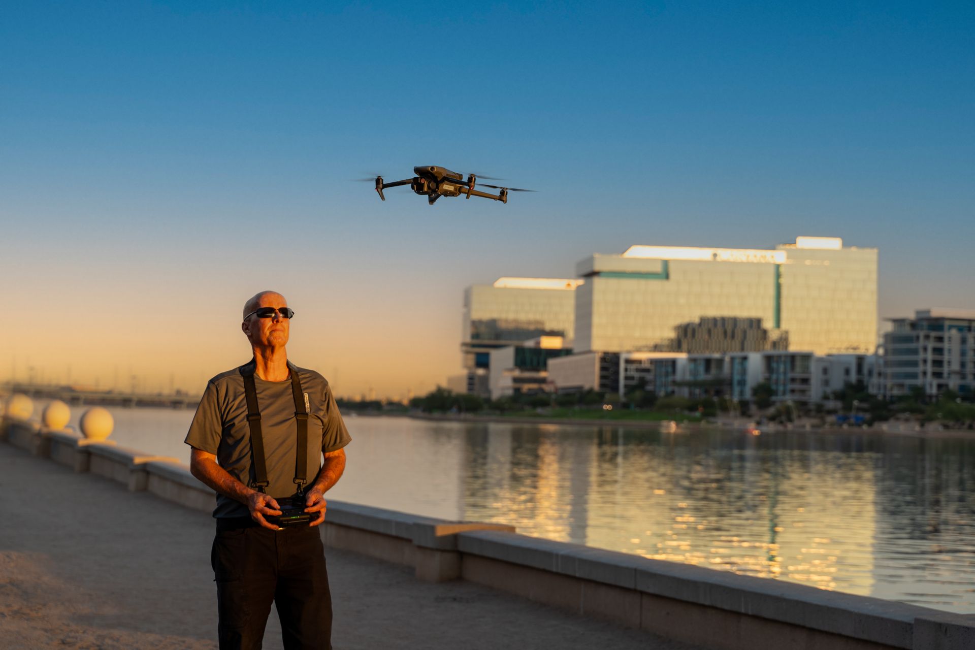 Photo by Phoenix Drone Pros, Robert Biggs, A man is flying a drone over a body of water.