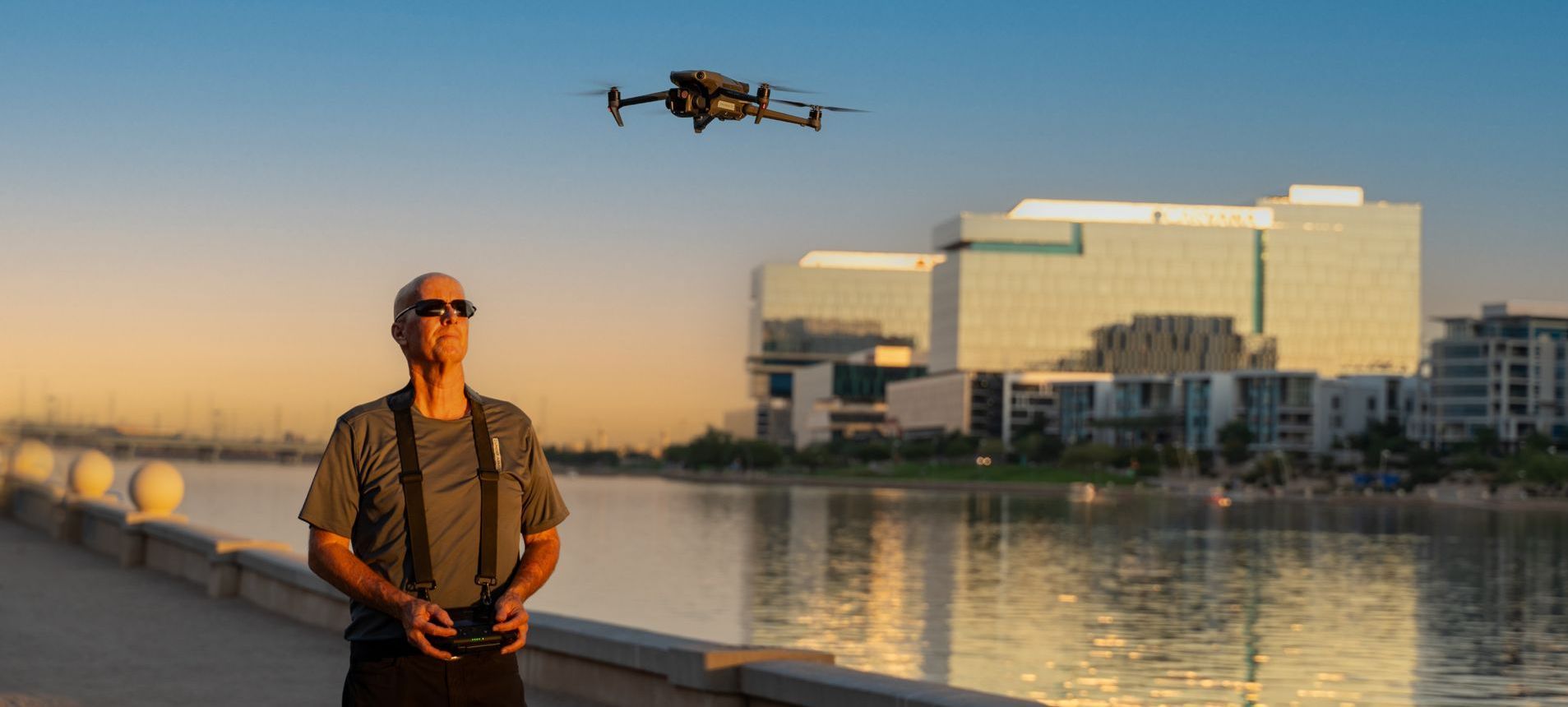 Photo by Phoenix Drone Pros, Robert Biggs, A man is standing next to a body of water while a drone flies overhead.