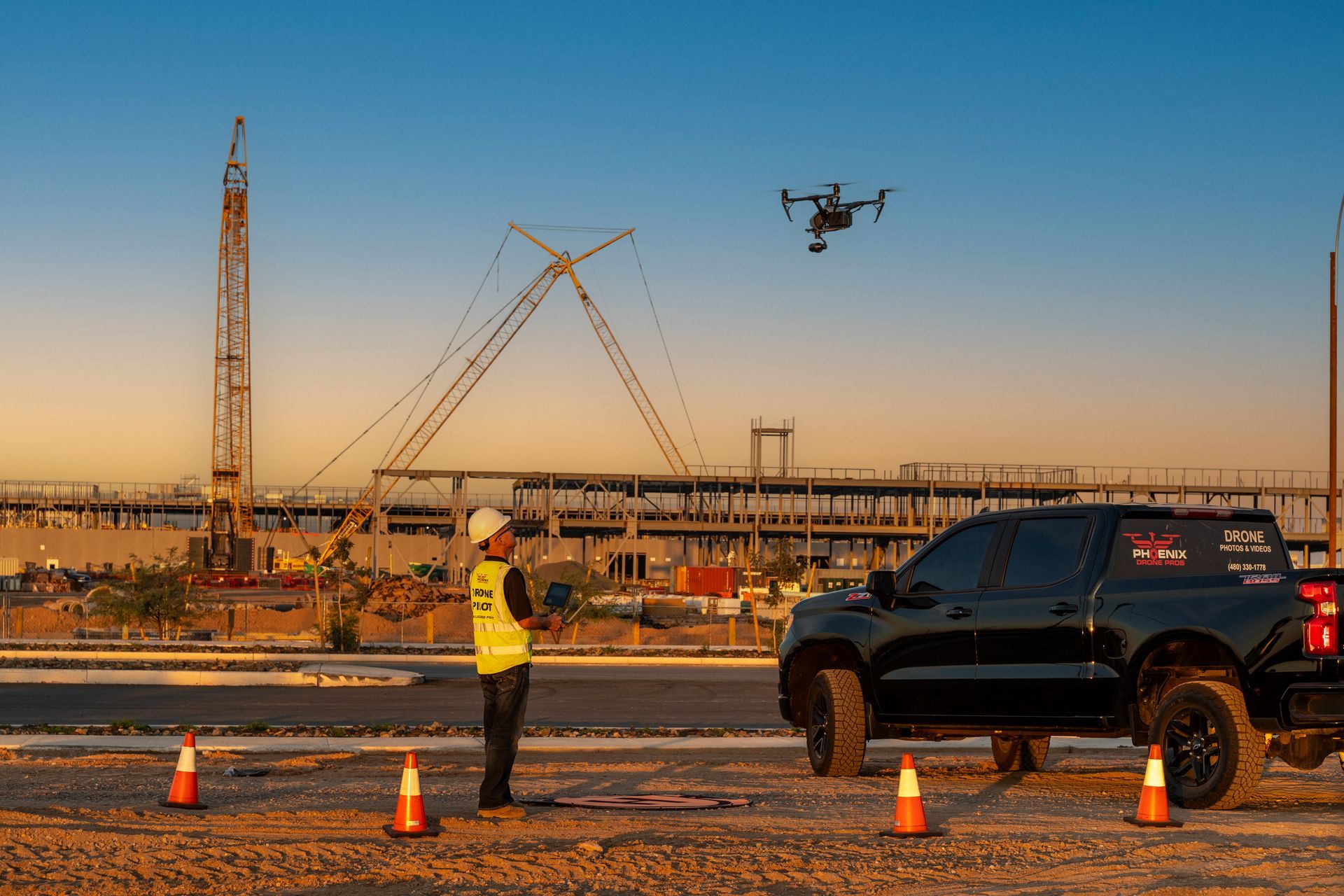 A man is flying a drone over a construction site. Photo by Phoenix Drone Pros, Robert Biggs,