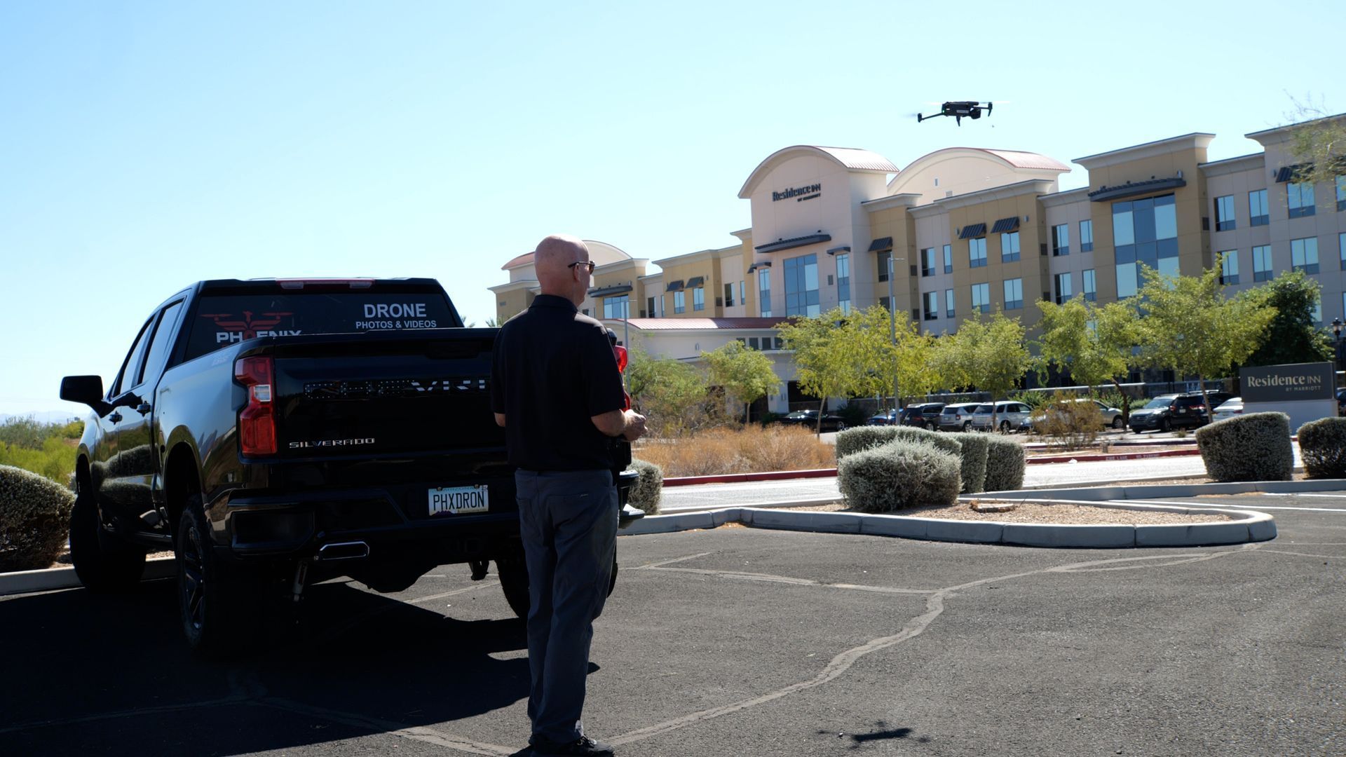 Photo by Phoenix Drone Pros, Robert Biggs, A man is standing next to a truck in a parking lot 