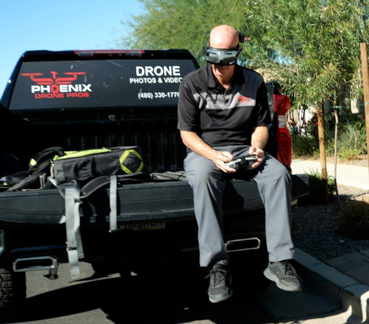 A man is sitting in the back of a phoenix drone pros truck, Photo by Phoenix Drone Pros, Robert Biggs