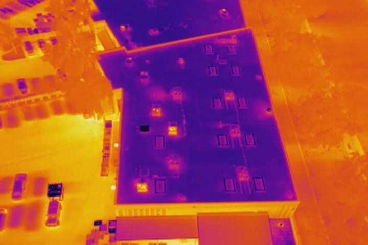 An aerial view of a building with a thermal image of the roof.