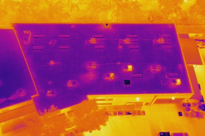 An aerial view of a building with a thermal image of the roof.