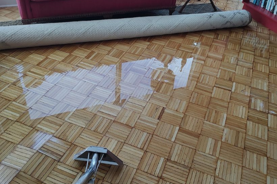 Professional water extraction equipment removing standing water from a flooded room