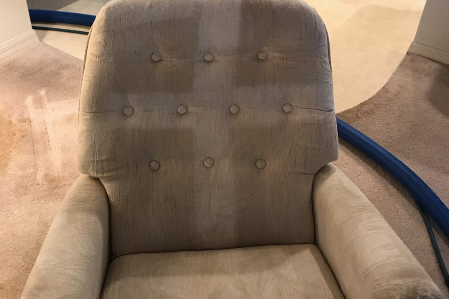 Before and after professional upholstery cleaning on armchair showing restored color and texture