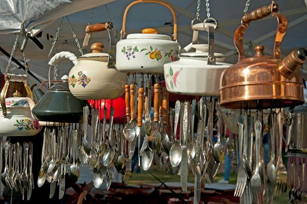a bunch of tea kettles and spoons hanging from chains