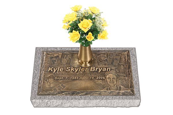 a gravestone with a vase of yellow roses on it .