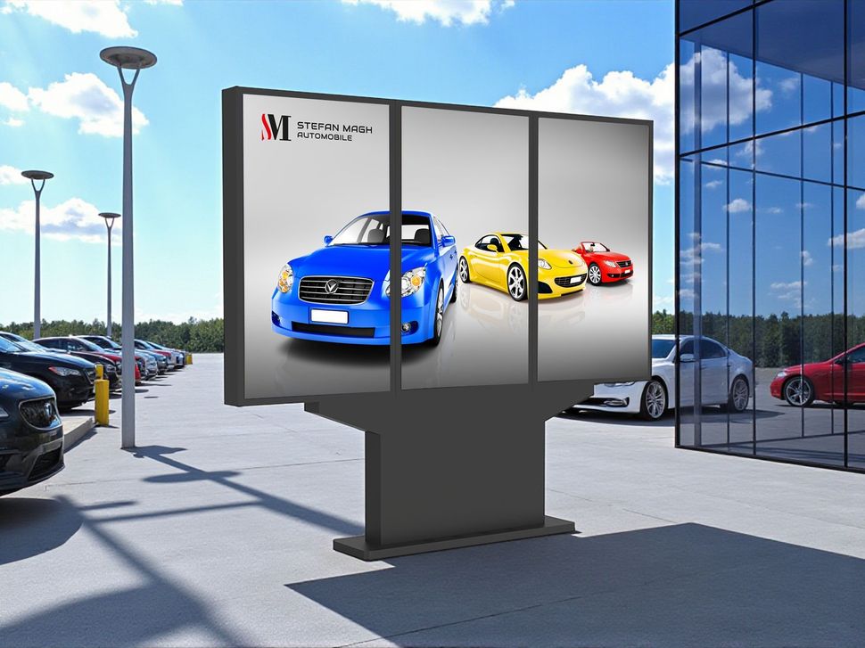 Eine Werbetafel mit drei Autoabbildungen ist in einem Autohaus ausgestellt.