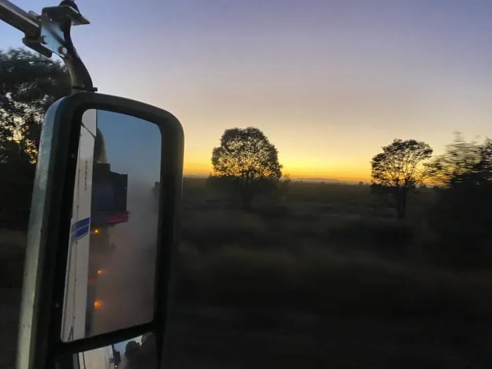 Sunset View From a Vehicle's Side Mirror, Trees Silhouetted Against a Golden Sky — Huntlys Heavy Equipment In Gracemere, QLD