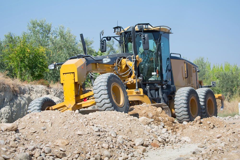 Yellow Motor Grader Grading Dirt on a Construction Site — Huntlys Heavy Equipment in Gracemere, QLD