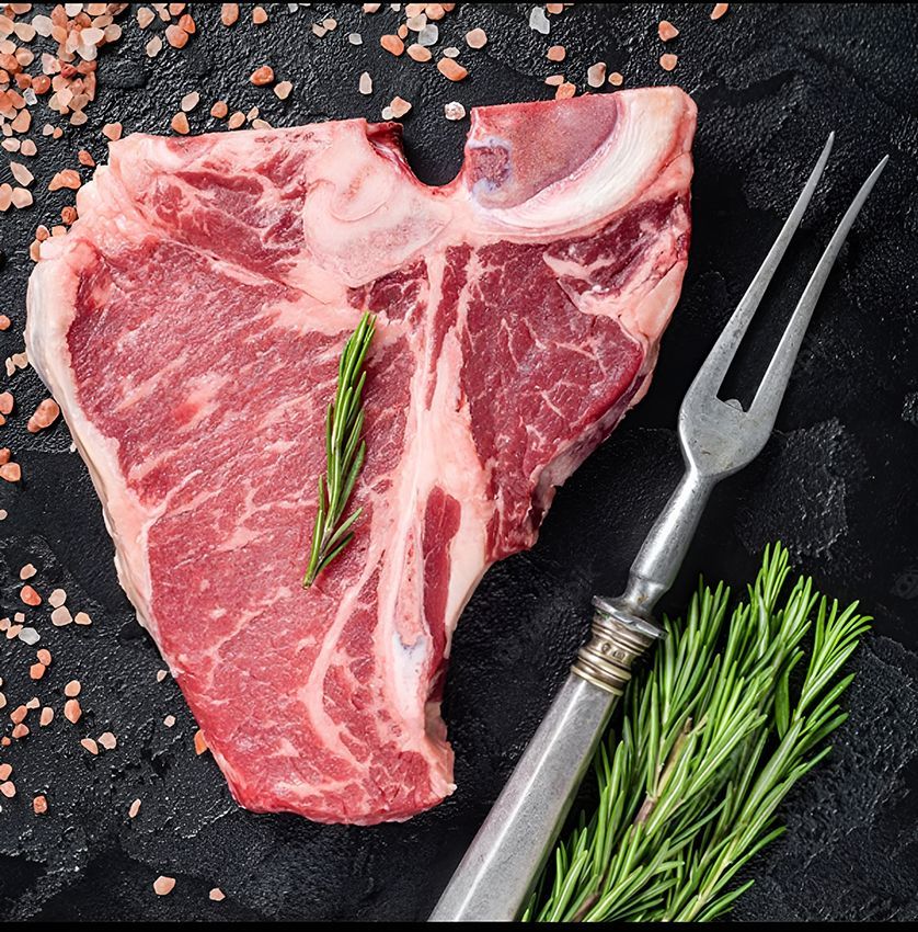 A Piece of Raw Meat with a Fork and Rosemary on a Table — Midway Butchers in South Innisfail, QLD