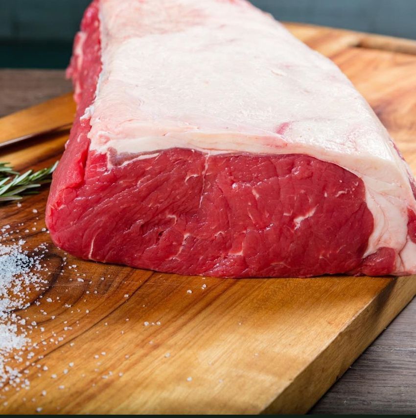 A Large Piece of Raw Beef on a Wooden Cutting Board — Midway Butchers in Tully, QLD