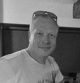 A man wearing sunglasses and a white shirt