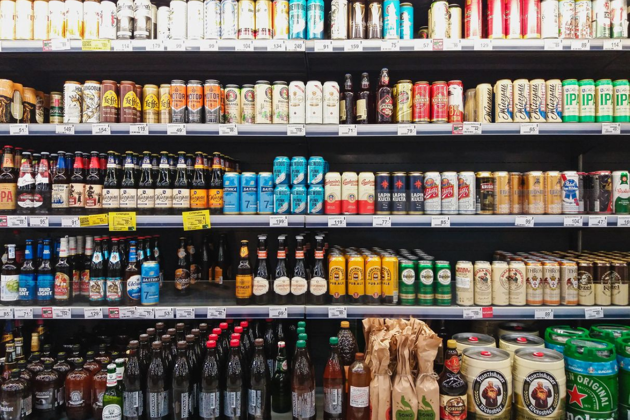 Grocery store beer and beverage aisle with rows of assorted bottles and cans on shelves