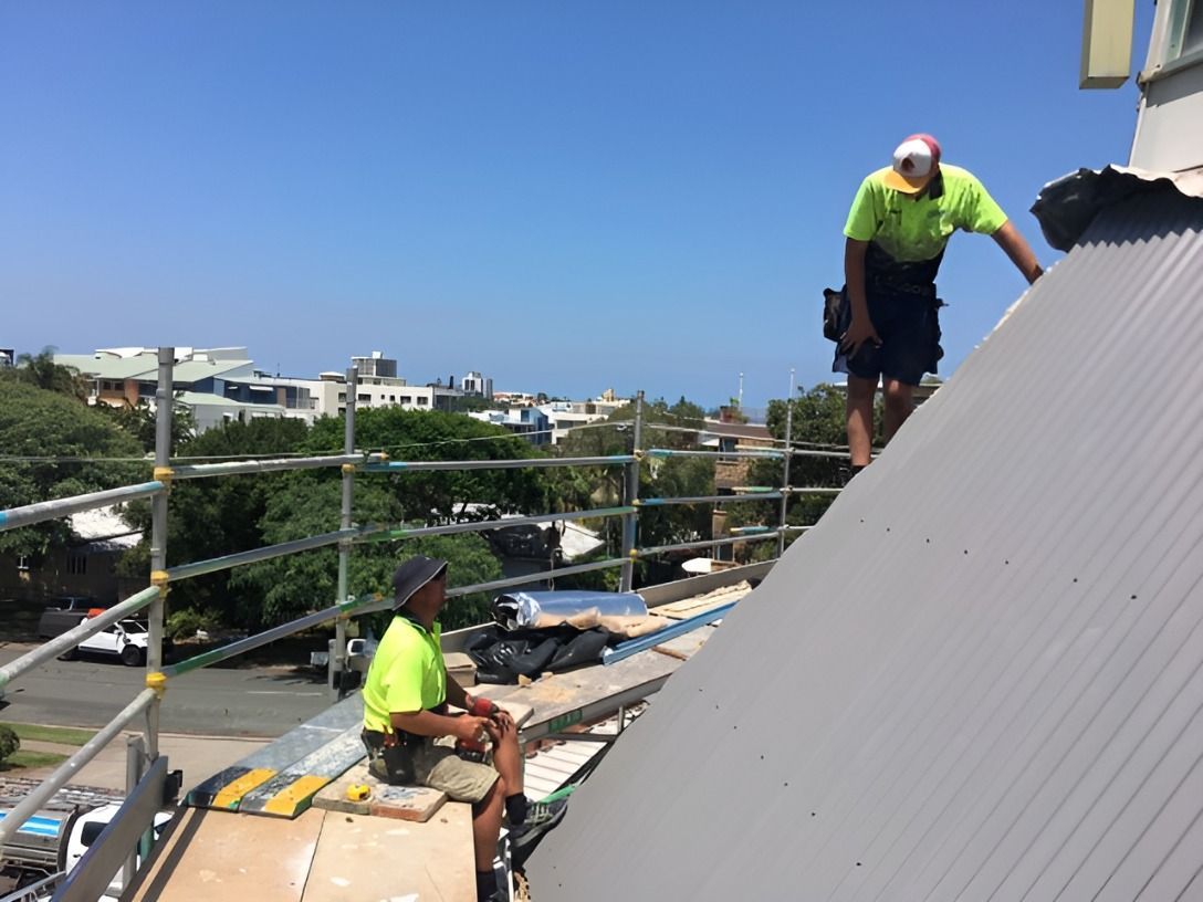 Two Men Are Working on the Roof of a Building — Roofing Revamped in Sippy Downs, QLD