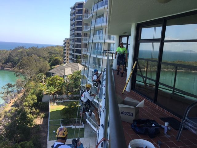 A Group of People Are Working on a Balcony of a Building — Roofing Revamped in Maroochydore, QLD