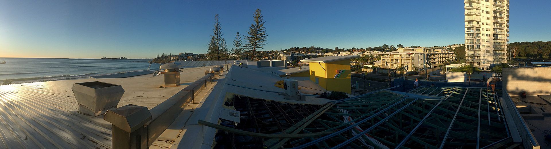 A Roof Under Construction and a Building in the Background — Roofing Revamped in Marcoola, QLD