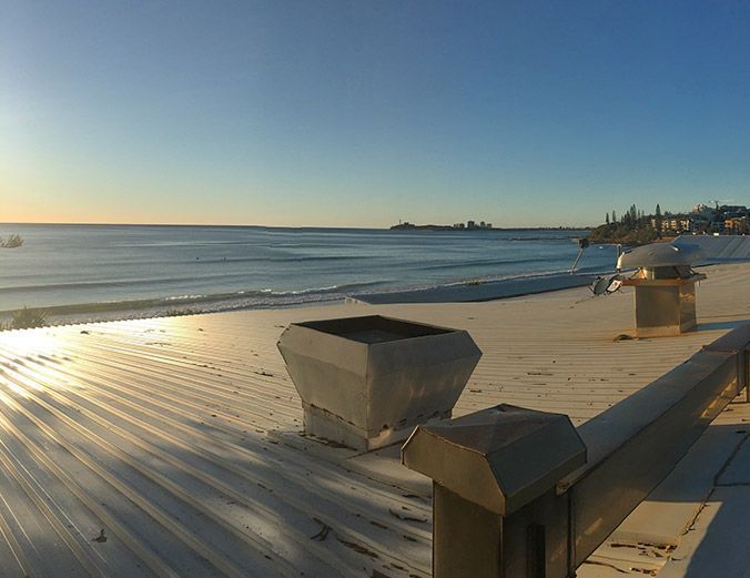 A view of the ocean from a deck with a chimney on it