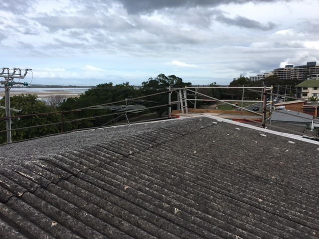 A Roof With A Scaffolding On It And A View Of The Ocean — Roofing Revamped in Maroochydore, QLD