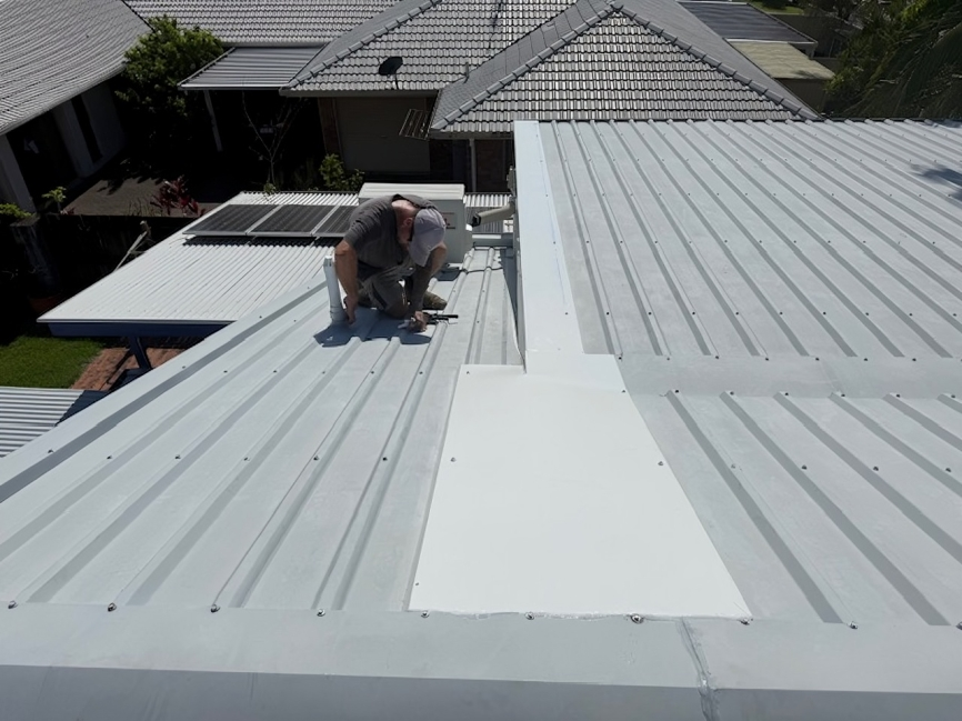 A Man is Sitting on a Scaffolding on Top of a Building — Roofing Revamped in Maroochydore, QLD